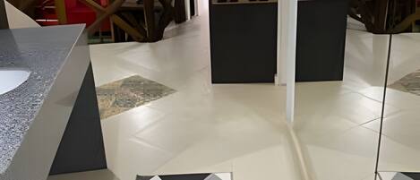Ein modernes Interieur mit geometrischen Bodenfliesen, einer Rezeption und Blick ins Freie.