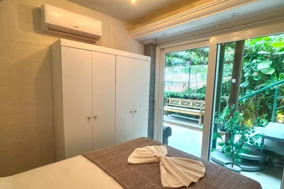 A bedroom with a bed, a wardrobe, and a ceiling light fixture.