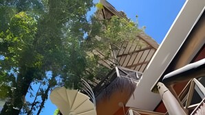 A unique architectural structure with a spiral staircase and multiple levels, surrounded by greenery. - Pousada Asa Delta Jurerê (Florianopolis)