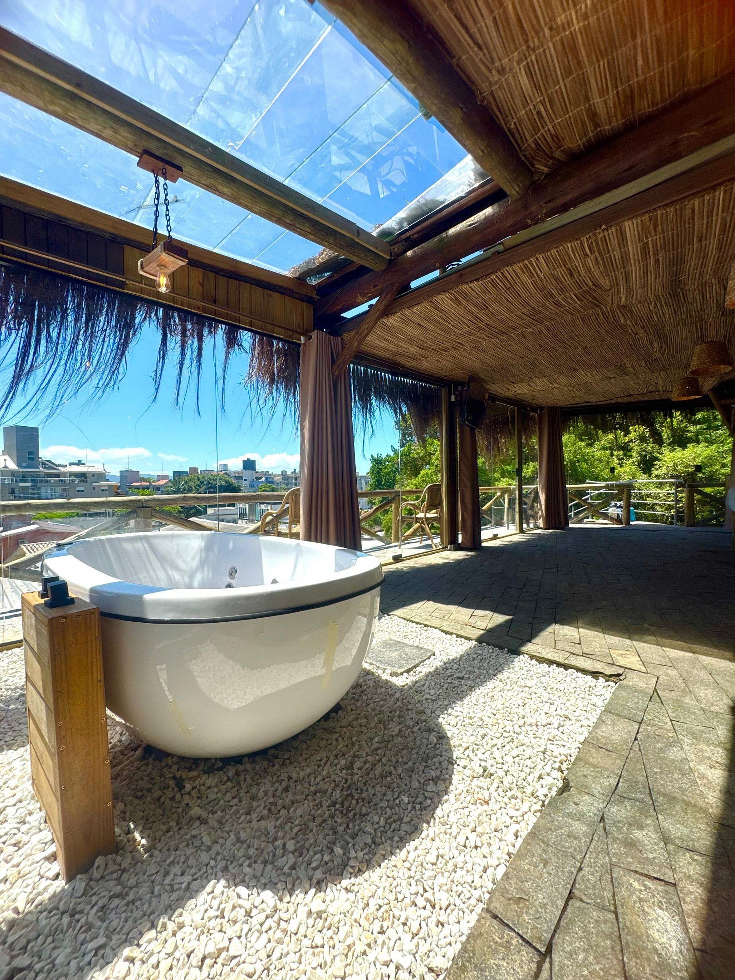 A hot tub in a covered outdoor area with a view of the city.