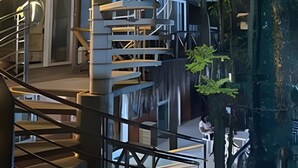 A modern building with multiple levels, featuring a spiral staircase and outdoor seating areas. - Pousada Asa Delta Jurerê (Florianopolis)