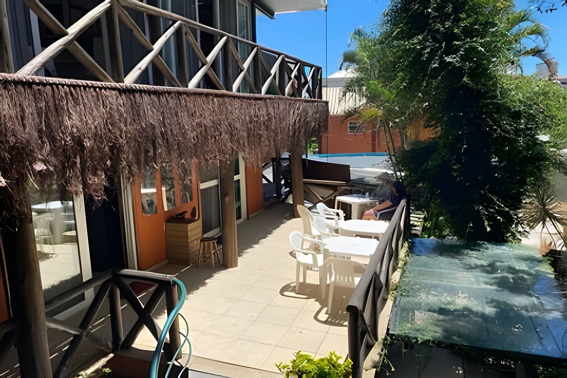Eine Terrassenfläche mit Sitzgelegenheiten und Blick auf einen Wasserlauf.
