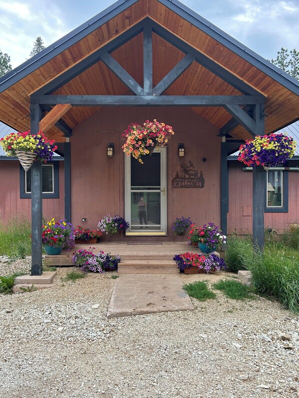Un bâtiment à la façade en bois, une enseigne accueillante et des arrangements floraux.