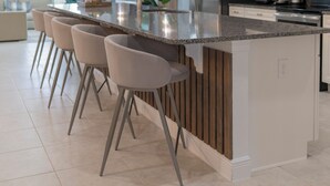 A modern kitchen with a central island, bar stools, stainless steel appliances, and pendant lighting. - Spectacular 9BR Villa Your Dream (Kissimmee)