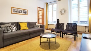 A living room with a grey sofa, two black chairs, a coffee table, and a framed picture on the wall. - Calm apt /60m2/near Notre-Dame and Seine/2bdrs (Paris)