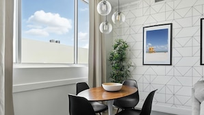 A dining area with a round wooden table, black chairs, a white bowl, and a framed picture on the wall. - South Beach Sleek 2BR Getaway (Miami Beach)
