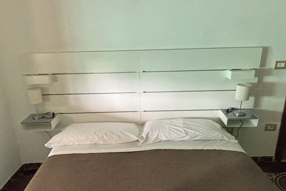 Ein ordentlich bezogenes Bett mit weißen Leinen in einem Hotelzimmer.