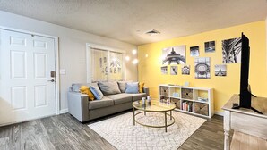 A living room with a grey sofa, a round coffee table, a bookshelf, and a fireplace. - PARIS - 2 beds / Free garage parking / Downtown Salt Lake City (Salt Lake City)