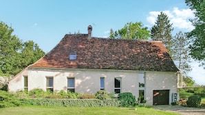 A two-story house with a sloped roof, a chimney, and a small window on the second floor.