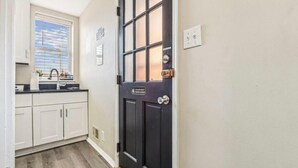 A narrow hallway leading to a black door with a sign that reads "Please keep door closed." - Camden's Little Charm-Walking Distance Stadium & Convention, University of MD (Baltimore)