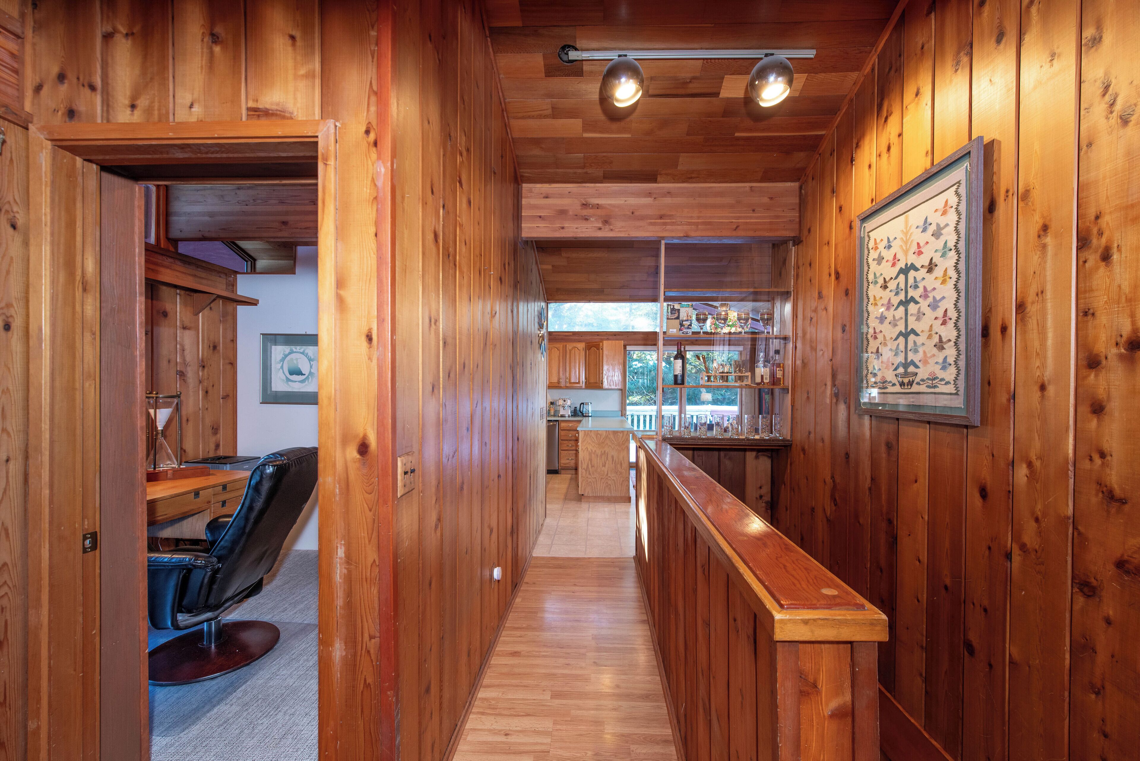 Un intérieur en bois comprenant un bar, un espace repas et une cuisine.