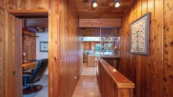 A wooden interior with a bar area, a dining space, and a kitchen.