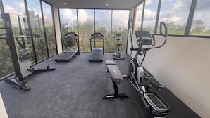 A gym with treadmills, elliptical machines, and a bench. - Hermosa Villa en Tulum (Tulum)