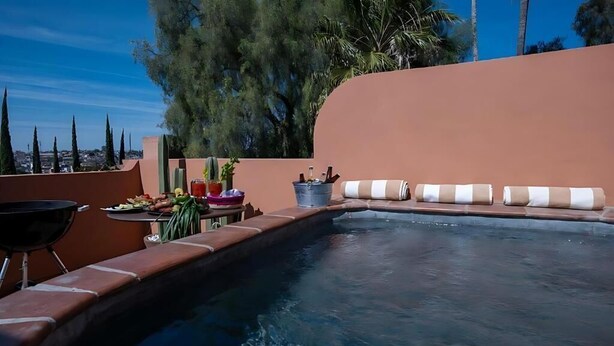 Una piscina con una tumbona y una parrilla.