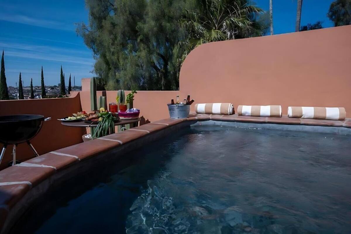 Une piscine avec des chaises longues et un barbecue.