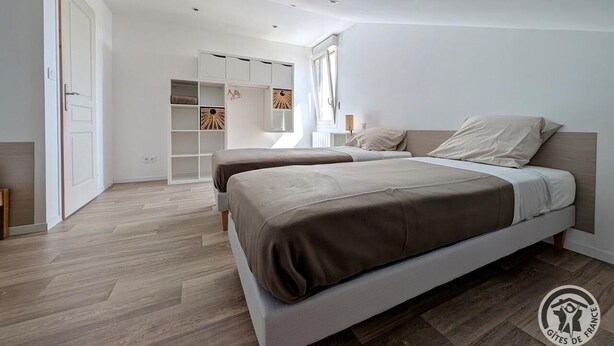 A modern bedroom with two beds, a built-in wardrobe, and a large window. - Les Hautes Collières - ECHALAS (ECHALAS)