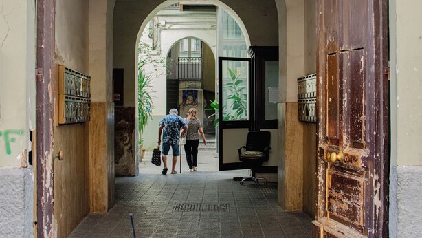 An arched entrance to a building with a wooden door and a metal gate. - House Mary (Napoli)