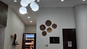 A modern interior with a ceiling light fixture, wall-mounted decorative items, and a door with a no entry sign. - Urban Backpack. Nómadas Digitales, Coworking wifi free 7/24. Rest and Chill (San Salvador)