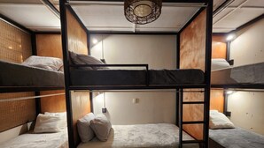 A bunk bed room with a wooden headboard, a small ladder, and a single light fixture. - Urban Backpack. Nómadas Digitales, Coworking wifi free 7/24. Rest and Chill (San Salvador)