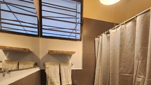 A compact bathroom with a toilet, sink, and shower curtain. - Urban Backpack. Nómadas Digitales, Coworking wifi free 7/24. Rest and Chill (San Salvador)