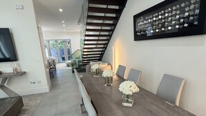 Un comedor moderno con una mesa larga, sillas y una escalera.