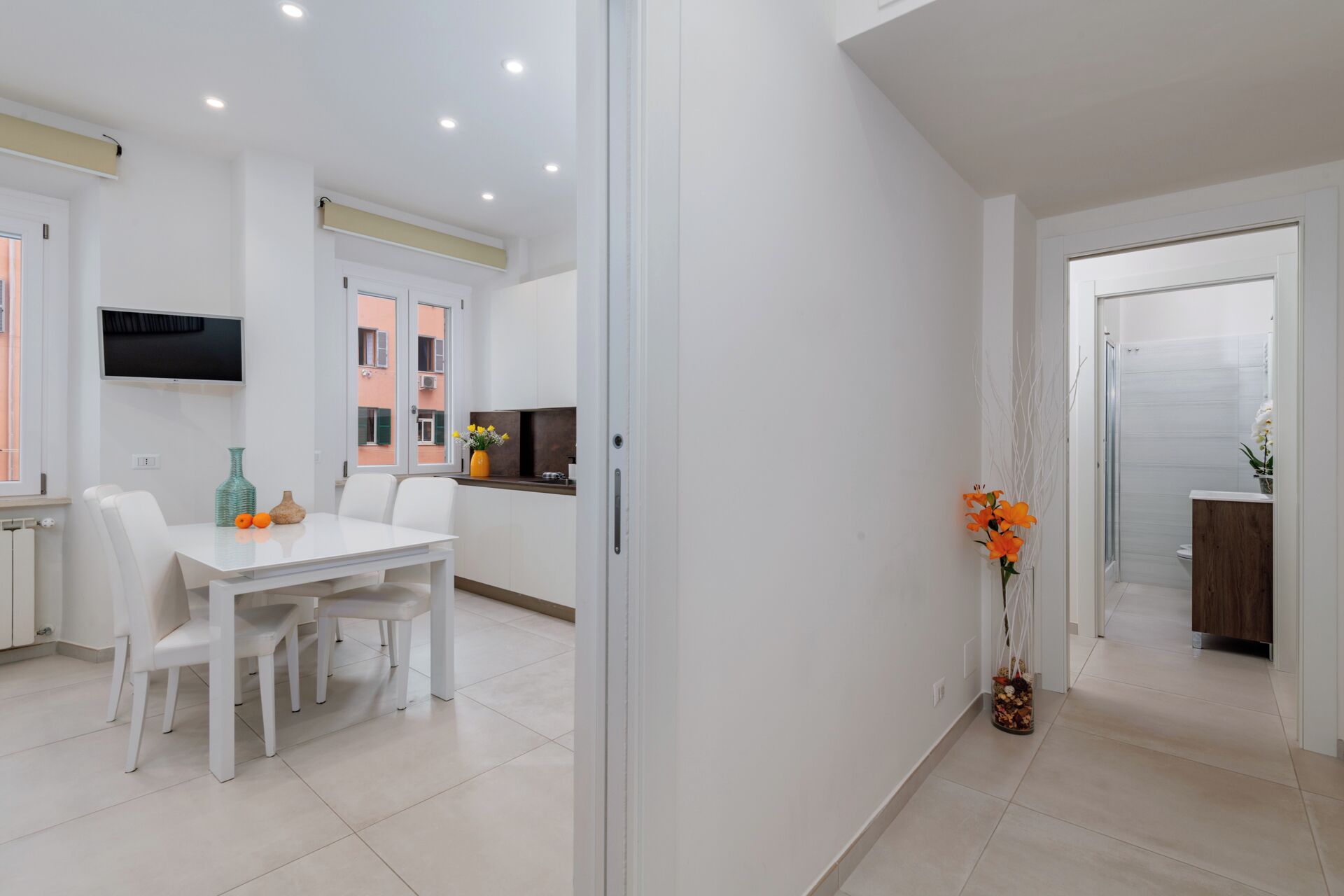 Una cocina moderna con armarios blancos, horno integrado y ventana con vistas al exterior.