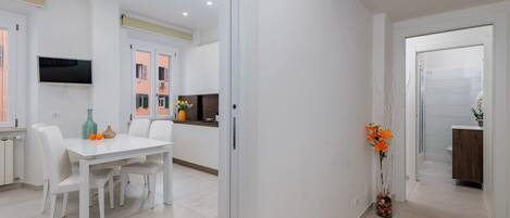 Una cocina moderna con armarios blancos, horno integrado y ventana con vistas al exterior.