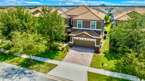 A residential area with houses featuring a consistent architectural style, a well-maintained lawn, and a clear sky.
