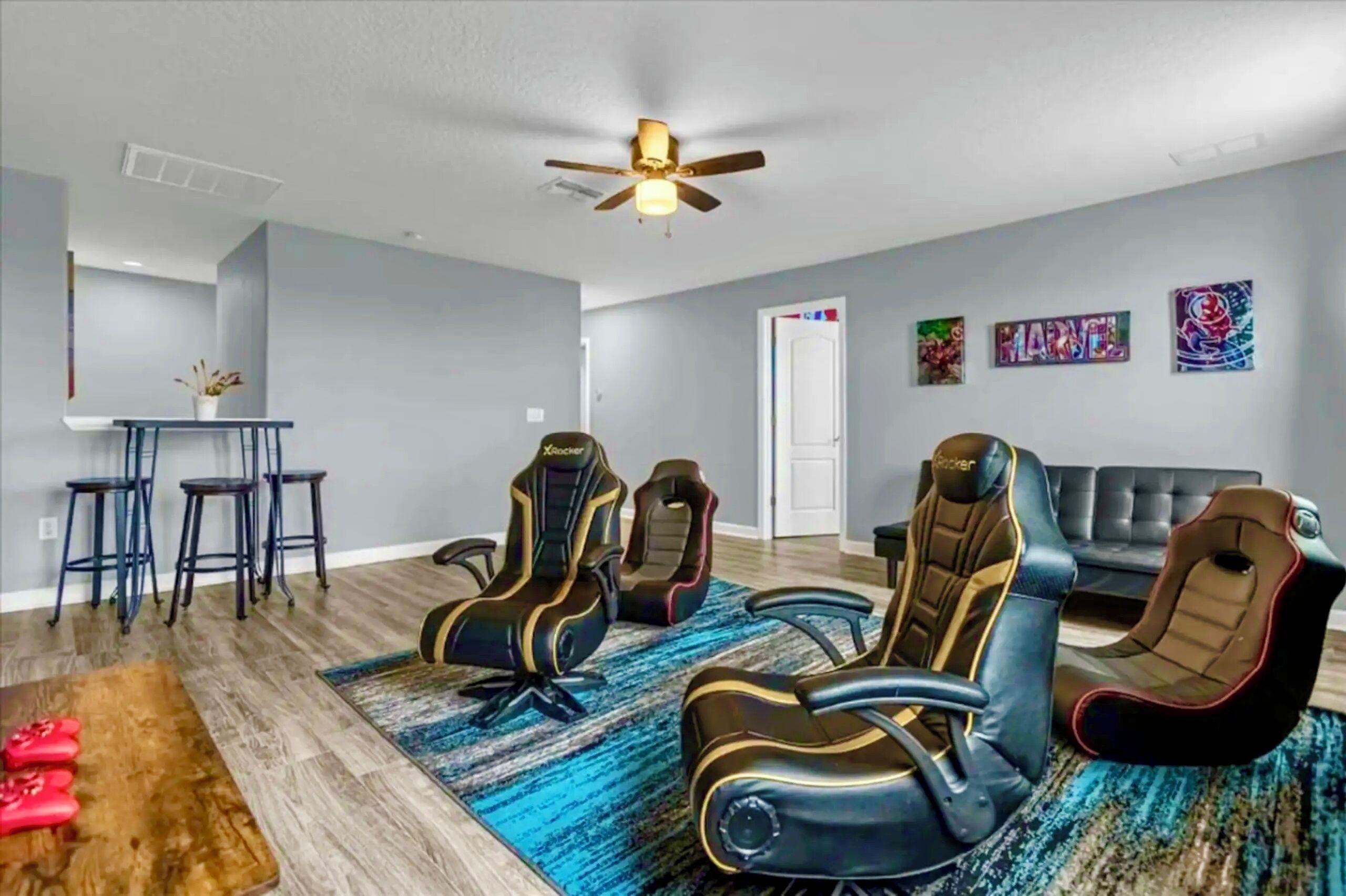 A modern living room with gaming chairs, a coffee table, and a sofa.