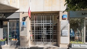 A building entrance with a glass door, a sign indicating '46A', and a flag. - Mokotowska Superior Apartment (Warszawa)