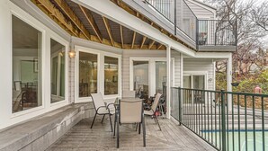 A covered patio with outdoor furniture, a pool, and a wooden deck.