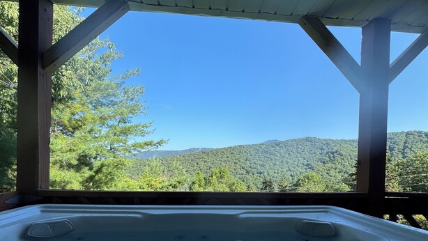 A hot tub under a wooden pergola with a view of a forested hillside. - Beautiful mountain views for a fun, relaxing getaway! (Seven Devils)