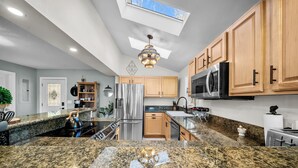 A modern kitchen with granite countertops, stainless steel appliances, wooden cabinets, and a skylight. - Beautiful mountain views for a fun, relaxing getaway! (Seven Devils)