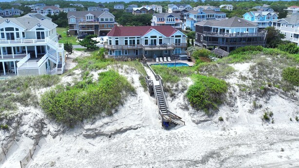 A beachfront property with multiple houses, a swimming pool, and a wooden walkway leading to the beach. - OCEANFRONT, priv pool & Hot Tub, Rec Room-WL1011, Sea Esta (Corolla)