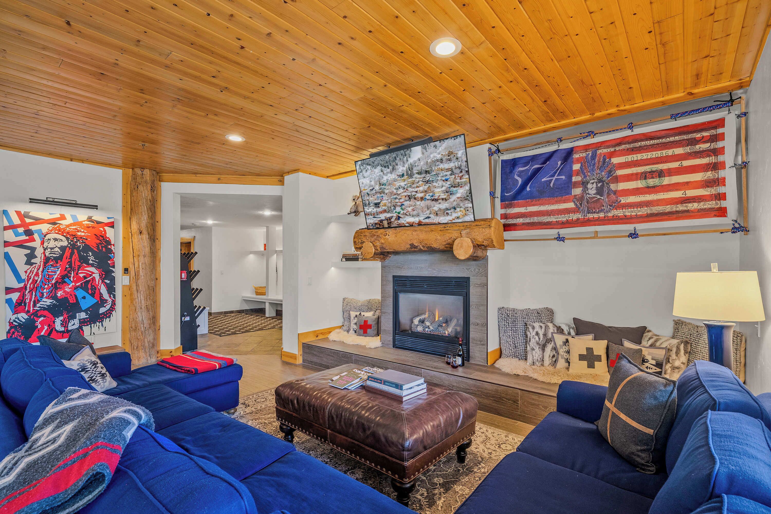 Ein Wohnzimmer mit Kamin, blauen Sofas, einem Couchtisch und einer großen amerikanischen Flagge.