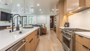 A modern kitchen with wooden cabinets, stainless steel appliances, and a central island.