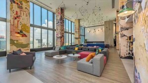 A modern lounge with large windows, a sectional sofa, and a coffee table.