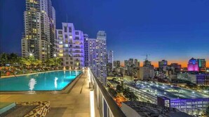 A high-rise hotel with a rooftop pool, offering city views.