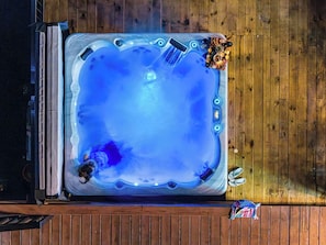 Een hottub met een houten terras eromheen.