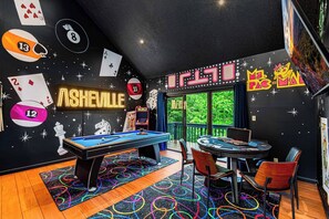 A billiards room with a pool table, chairs, and neon signs. - Asheville 6BR Retreat — Bowling Alley, Hot Tub, Sauna, Theater —  Sleeps 16 (Asheville)