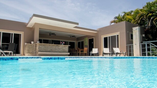 A swimming pool with a covered area and lounge chairs. - Luxury Caribbean 5BR Villa – Private Pool, BBQ & Ocean Breezes (Sosúa)