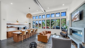 Una cocina moderna con comedor, sofá y chimenea.