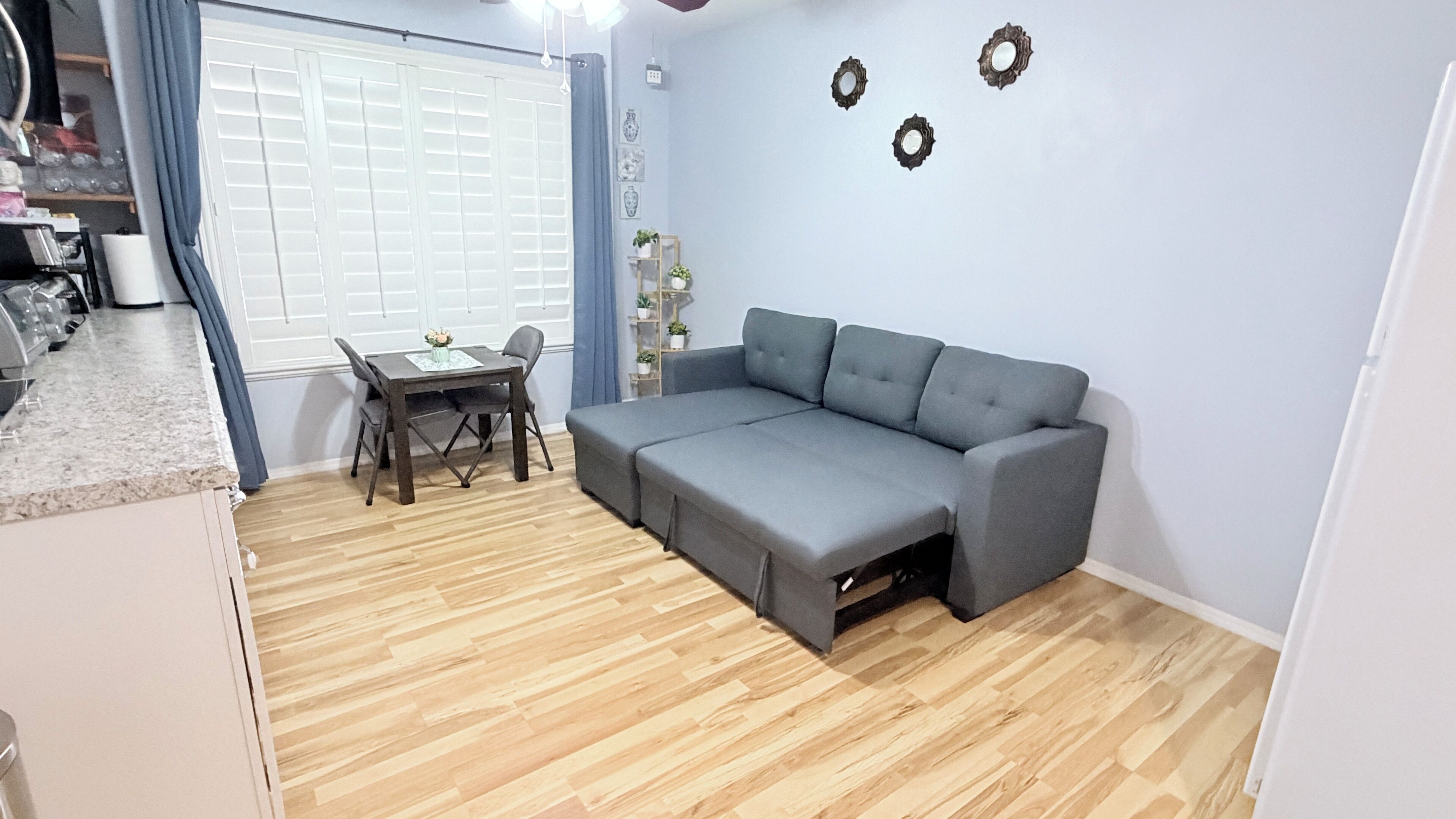 A compact living space with a sofa, a dining table, and a kitchen area.