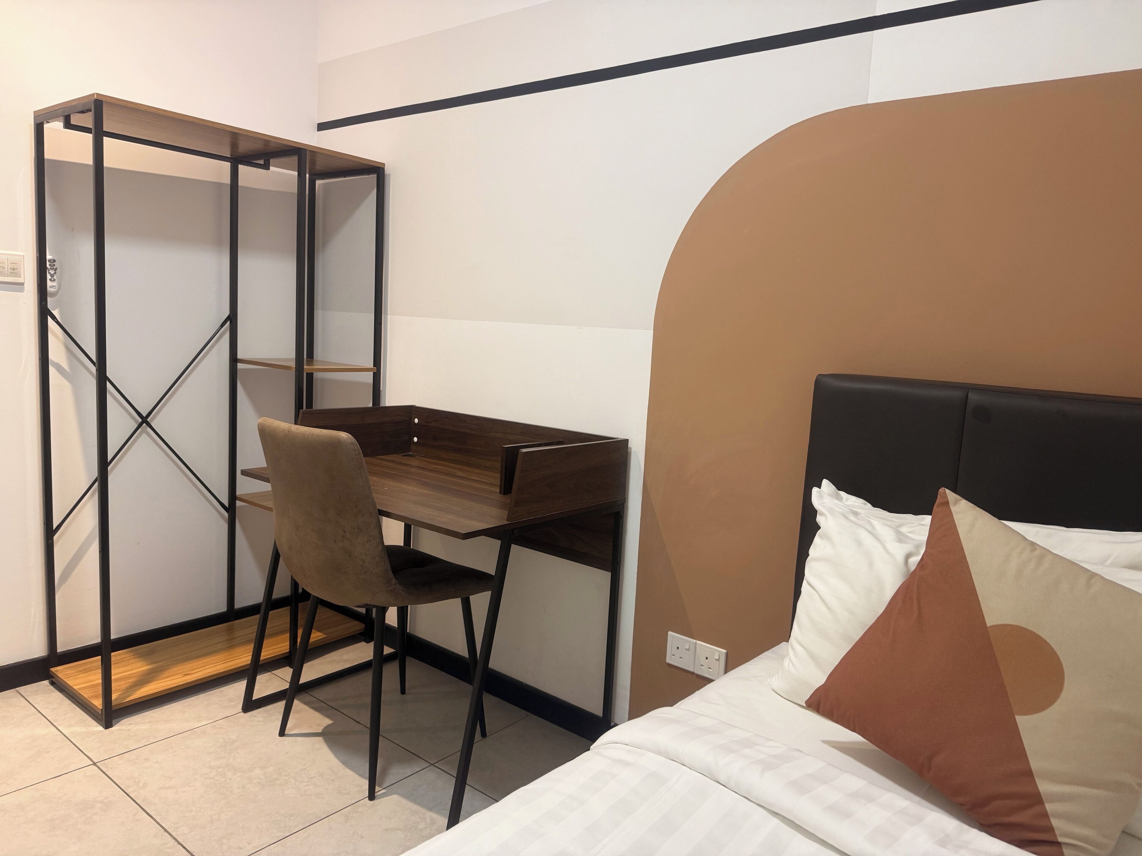 A compact room with a bed, a desk, and a chair.