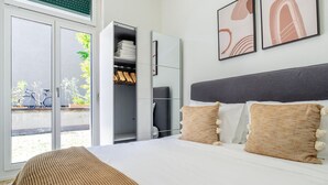 Un dormitorio con cama, armario y vistas al exterior.