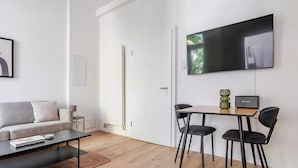Una sala de estar moderna con un sofá, una mesa de centro y un televisor montado en la pared.