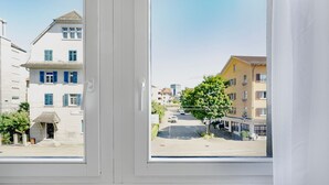 Een uitzicht op straat, gebouwen en een boom.