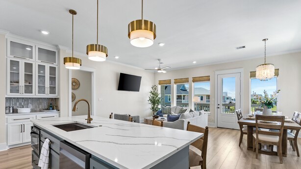 A modern kitchen with a large island, white cabinetry, and gold pendant lights. - Terramar Beach Escape + Easy Beach Access (Galveston)