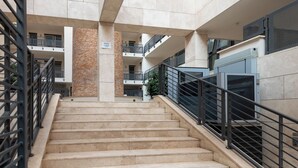Un intérieur à plusieurs niveaux, doté d’un escalier central, de rampes en métal et d’une colonne en briques.