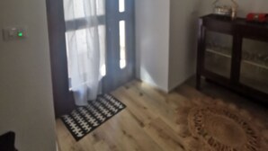 Une pièce avec un plancher en bois, un meuble de couleur sombre et un tapis à motifs.